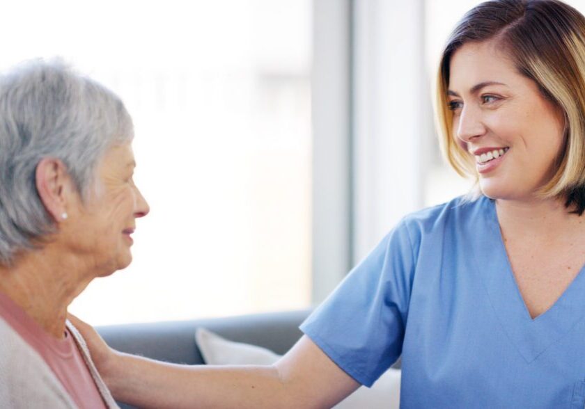 Nurse smiling and comforting elderly woman